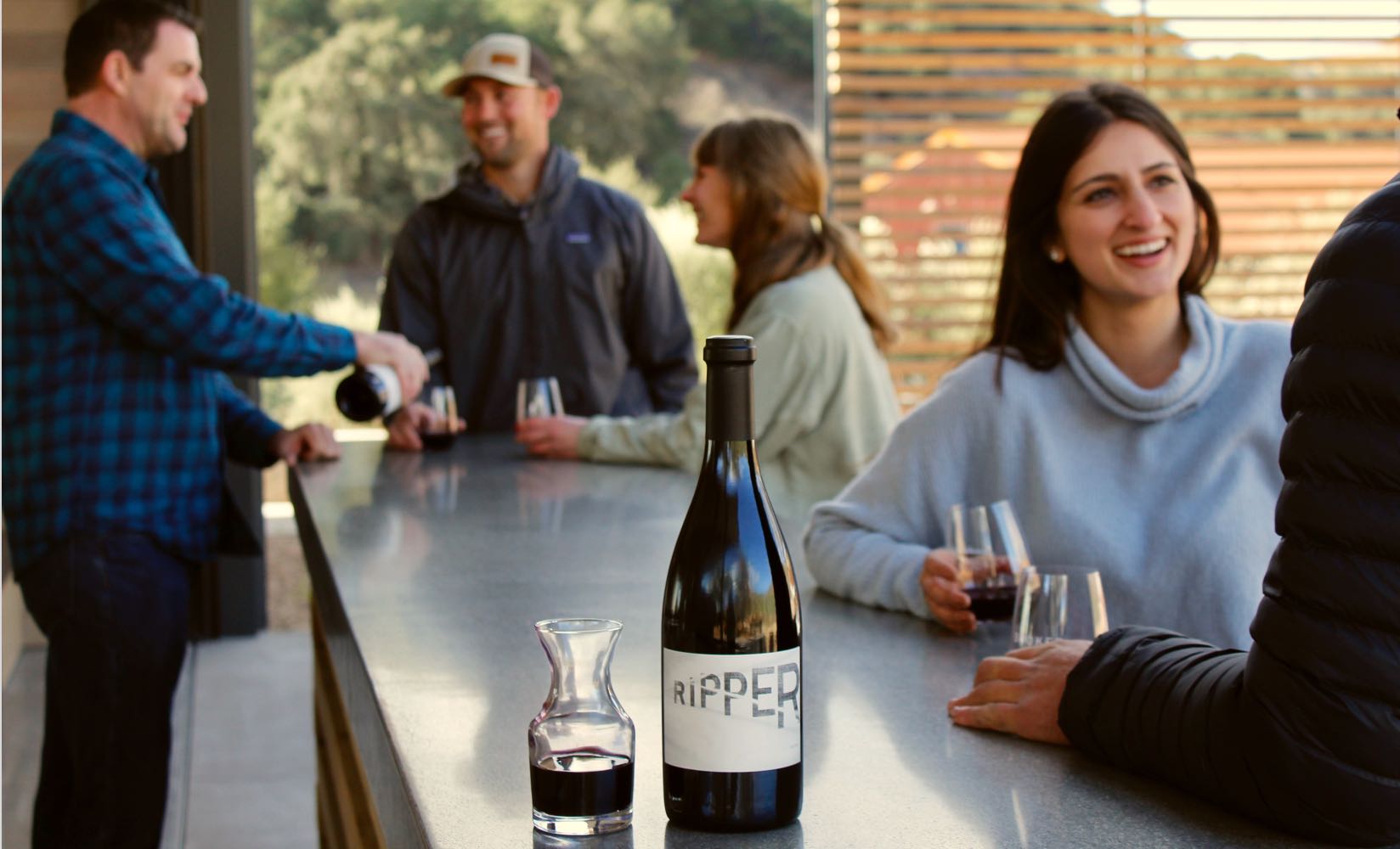 visitors wine tasting at the bar
